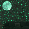 A dark green wall decorated with glowing teal stars and a large, bright cyan moon.