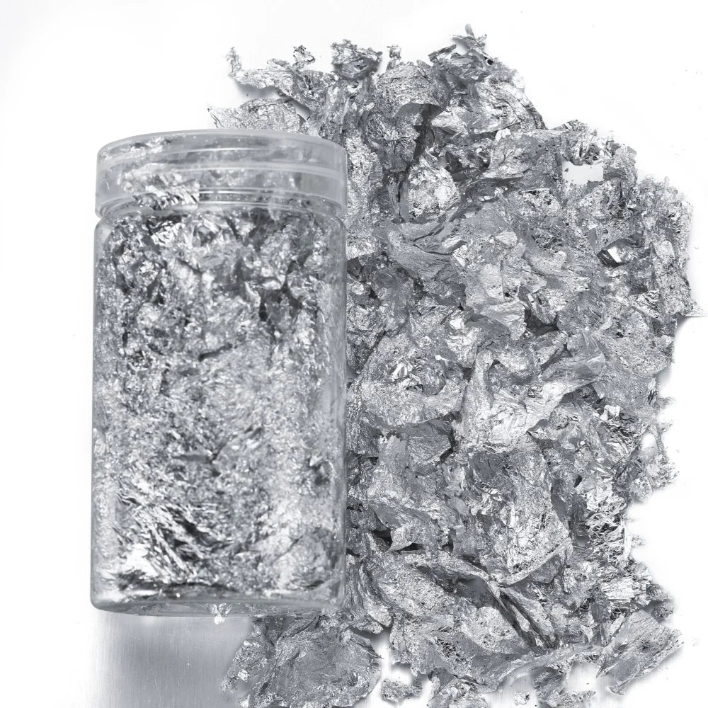 A clear jar filled with shiny gold foil flakes for resin art and jewelry making