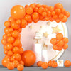 A large archway made of orange latex balloons decorated with gold stars and a single orange balloon.