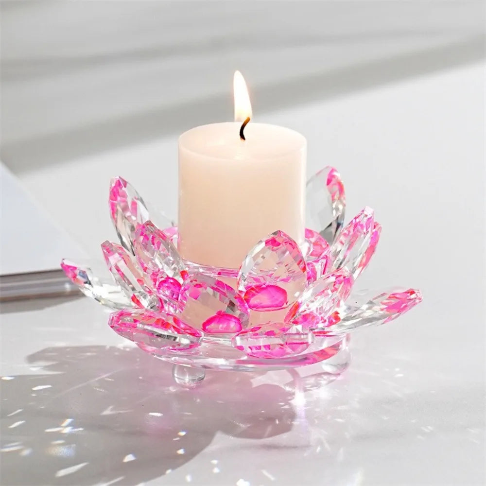 A clear crystal lotus candle holder with a pink flame and a pale pink candle.