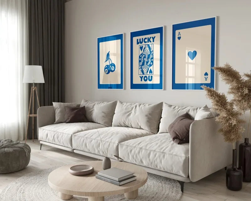 A modern living room features a light sofa, wooden coffee table, and framed art prints on the wall.