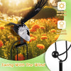 A black wind spinner garden decoration featuring a bird silhouette, shown outdoors with sunlight and flowers.