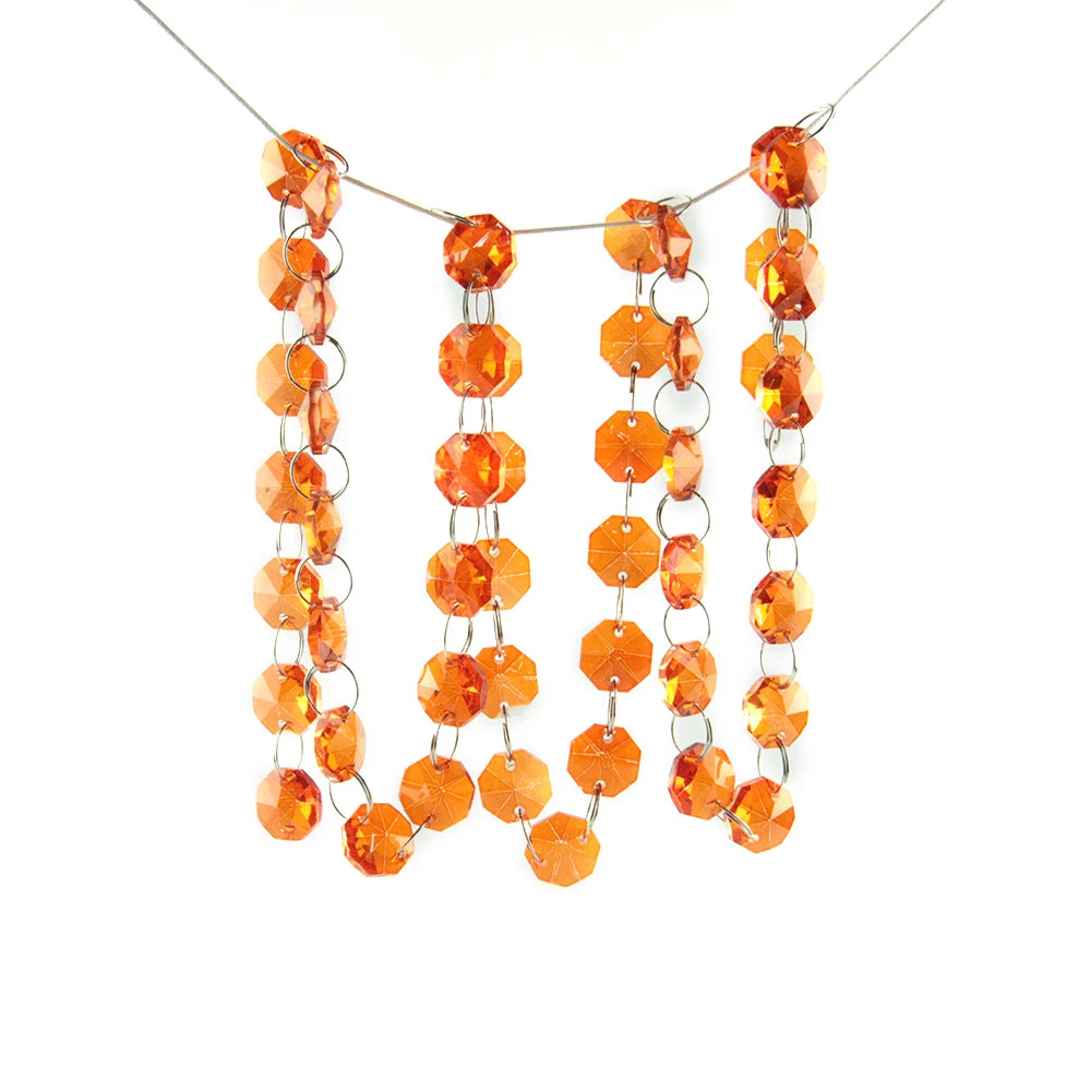 A strand of crystal glass octagon beads in warm orange tones hanging from a thin wire.
