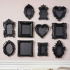 A collection of black, ornate resin wall decor pendants in various heart and oval shapes.