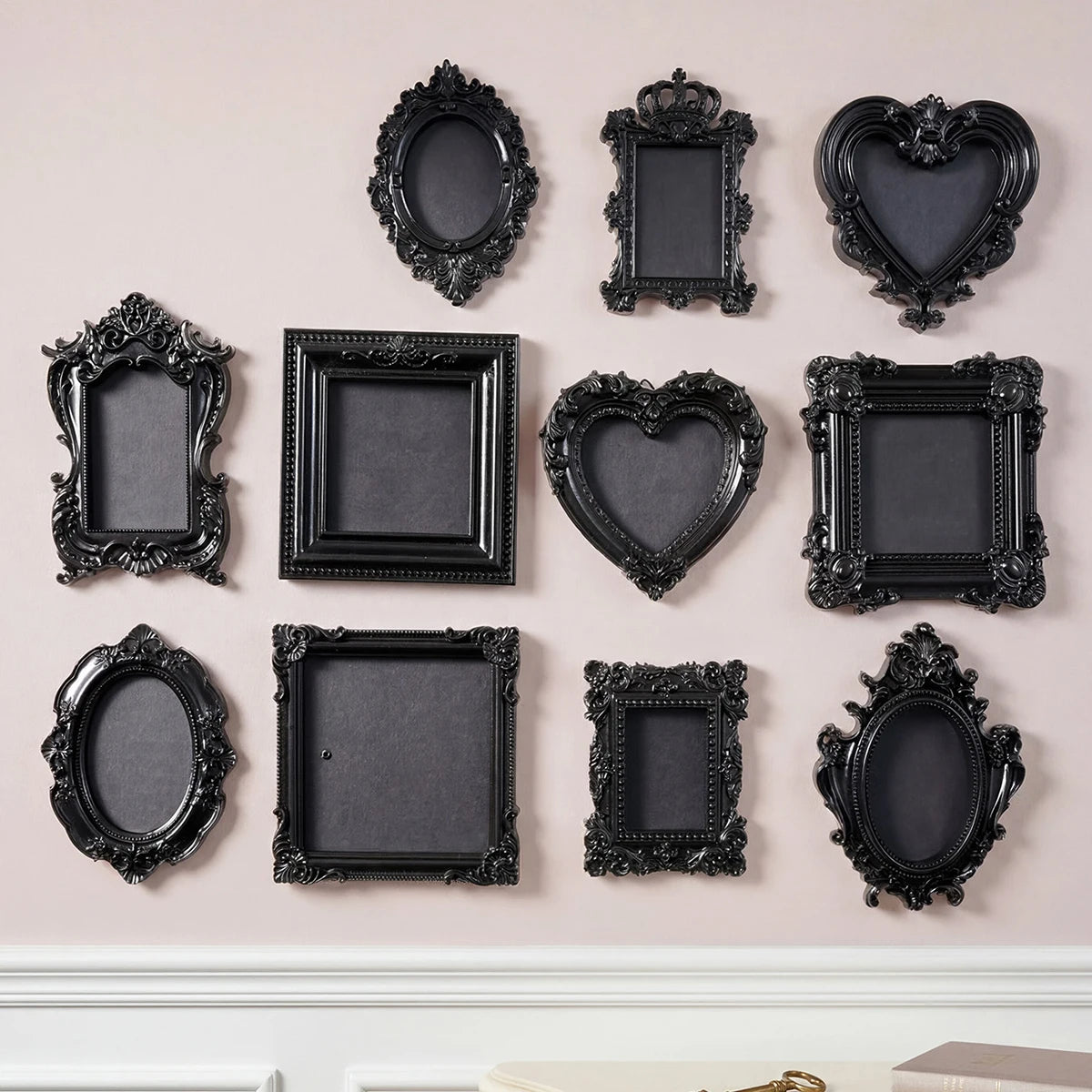 A collection of black, ornate resin wall decor pendants in various heart and oval shapes.
