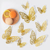 A collection of decorative gold-colored 3D butterfly wall stickers and natural fruit slices on a wooden surface.