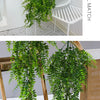 A lush green artificial ivy vine garland displayed in two styles: a top potted arrangement and hanging from a wooden stand.