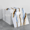 Stack of faux marble 3D self-adhesive wall tiles featuring blue and gold veining