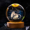 A spherical crystal ball decoration with a dark background showing a silhouette of a lion and the zodiac sign Cancer