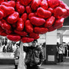 A close-up shot of a large cluster of red heart-shaped foil balloons.