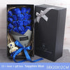 A gift box containing a bouquet of blue roses and a white bear, wrapped with a blue ribbon.