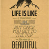 A vintage-style poster on kraft paper with text that reads Life is like a mountain hard to climb but once you get to the top 