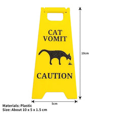 Yellow plastic yard sign with black silhouette of a cat and text warning about cat vomit.