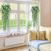 Three lifelike faux eucalyptus hanging plants displayed in a bright window setting.