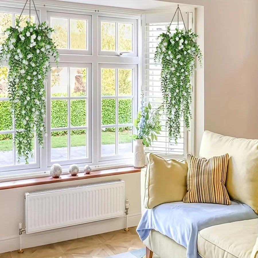 Three lifelike faux eucalyptus hanging plants displayed in a bright window setting.