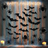 A display of black bat and spider silhouettes on a wooden wall for Halloween décor.