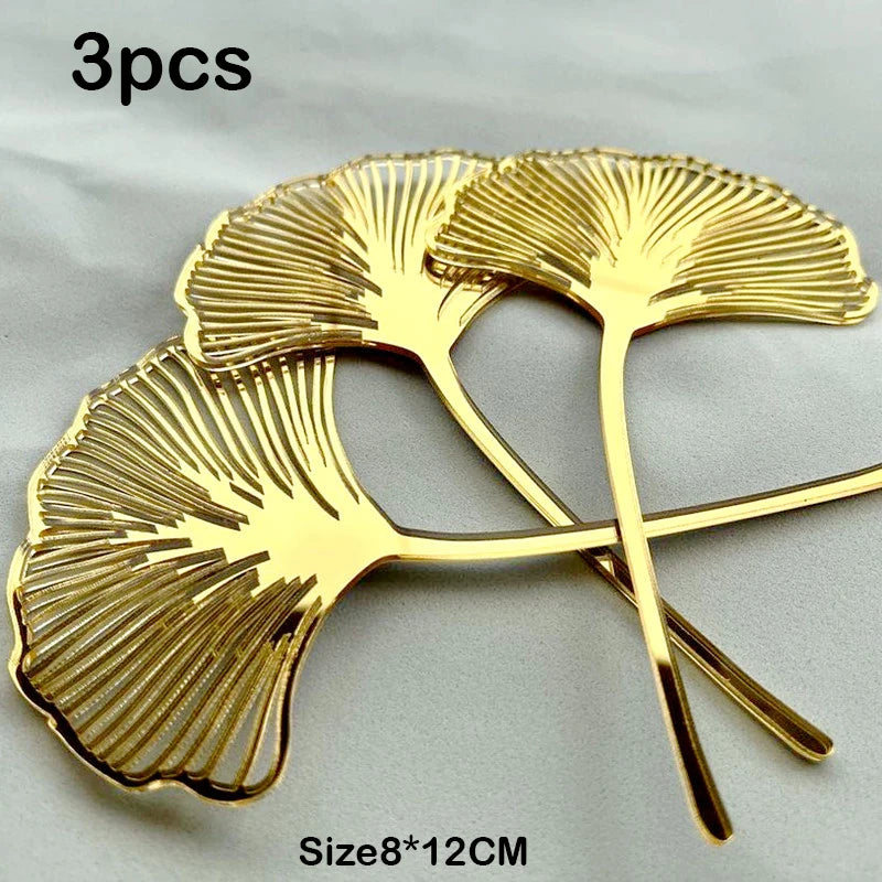 A set of three golden palm leaf cake toppers with flower decoration, measuring 8 by 12 cm.