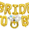 A gold foil balloon banner spelling the word BRIDE TO BE