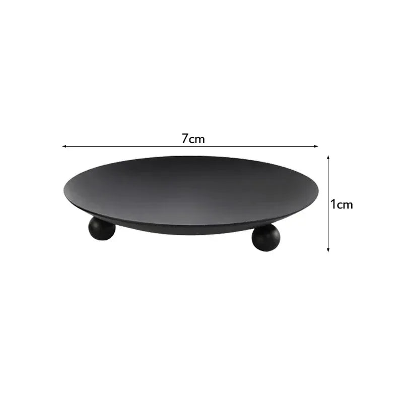 A black iron candle holder tray with gold accents, shown from the top view.