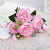 A bouquet of pink silk rose and peony artificial flowers displayed on a white surface.