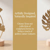 A set of gold-toned sculptural ginkgo leaf ornaments displayed on a light wooden surface.