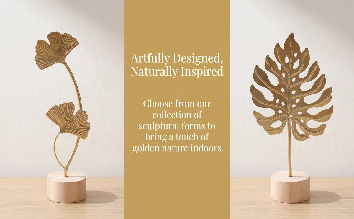 A set of gold-toned sculptural ginkgo leaf ornaments displayed on a light wooden surface.