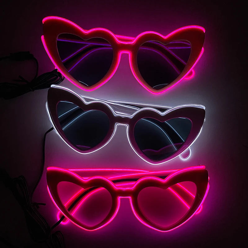 Three pairs of heart-shaped LED wire party glasses glowing in pink and purple light.
