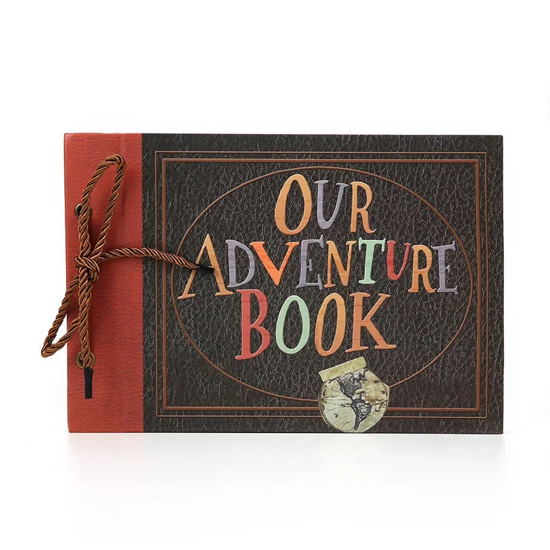 Album photo brun foncé avec couverture orange-rouge et fermeture en ficelle dorée, texte Our Adventure Book.