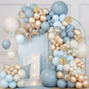 A large balloon wreath featuring blue, sand, white, and gold latex balloons arranged in a vertical display.