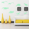 A white wall decorated with light green dinosaur silhouettes and a yellow vase on the floor.