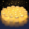 A cluster of glowing yellow votive tea lights arranged on a dark surface against a starry background.