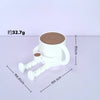 A white 3D printed figurine of a coffee bean cup with articulated joints, shown on a light purple surface.