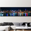 A canvas wall art print depicting the New York City skyline at night reflected on water.