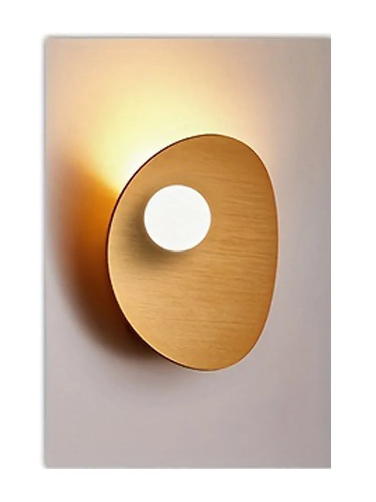 A round, copper-toned wall art piece featuring a circular cutout against a light gray background.