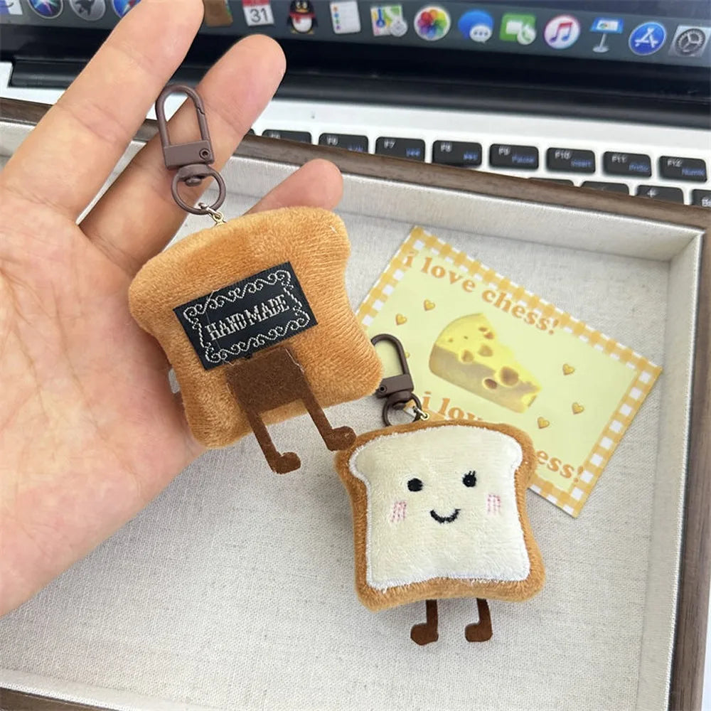 A plush keychain charm shaped like toast bread with a small cheese slice detail.