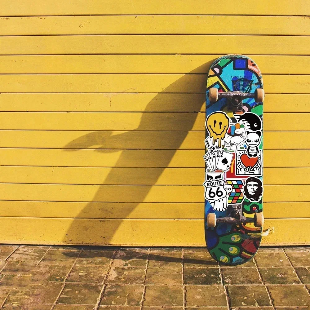 A skateboard featuring a colorful graphic design against a bright yellow wall.