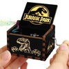 A carved wooden music box with an open lid featuring a Jurassic Park themed design.
