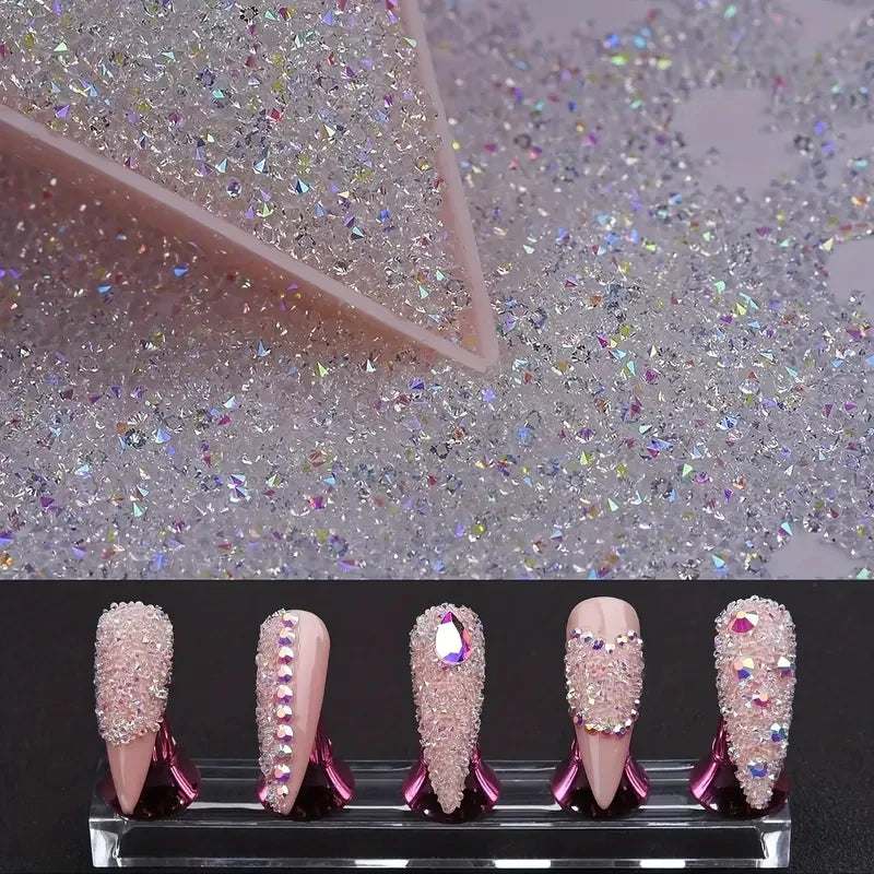A display of iridescent nail rhinestones and acrylic nails on a clear stand.