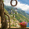 Vintage wicker key bell hanging with multiple brass bells against a scenic mountain landscape