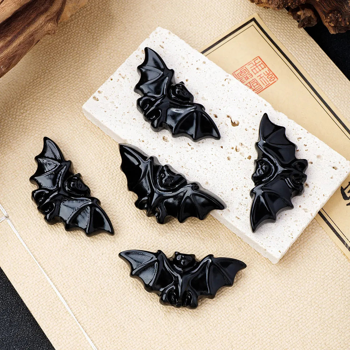 A set of black hand-carved obsidian bat figurines displayed on a light background.