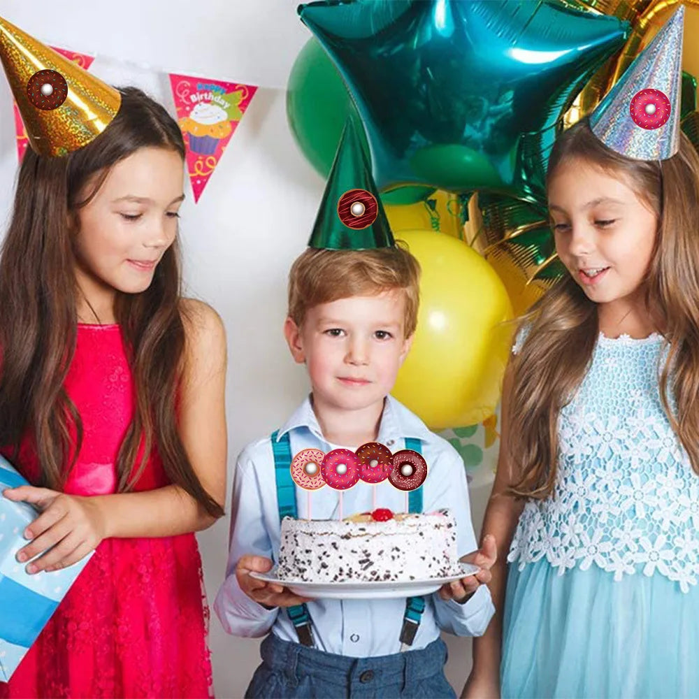 Three children smiling while holding a cake decorated with colorful frosting and surrounded by party decorations.