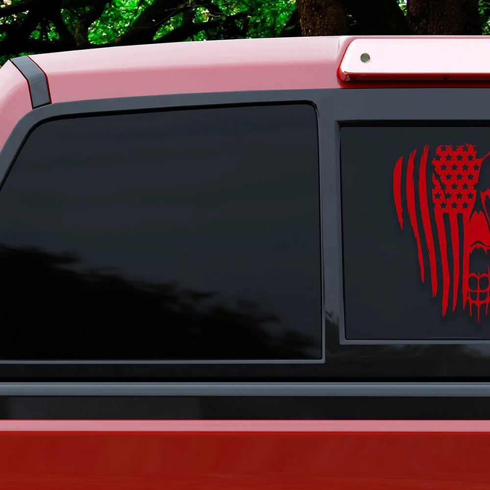 A close-up view of a red vehicle with a black window featuring a red patriotic skull decal.