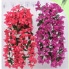 A display of vibrant pink and purple faux bougainvillea vines, showcasing colorful flowers on green foliage.