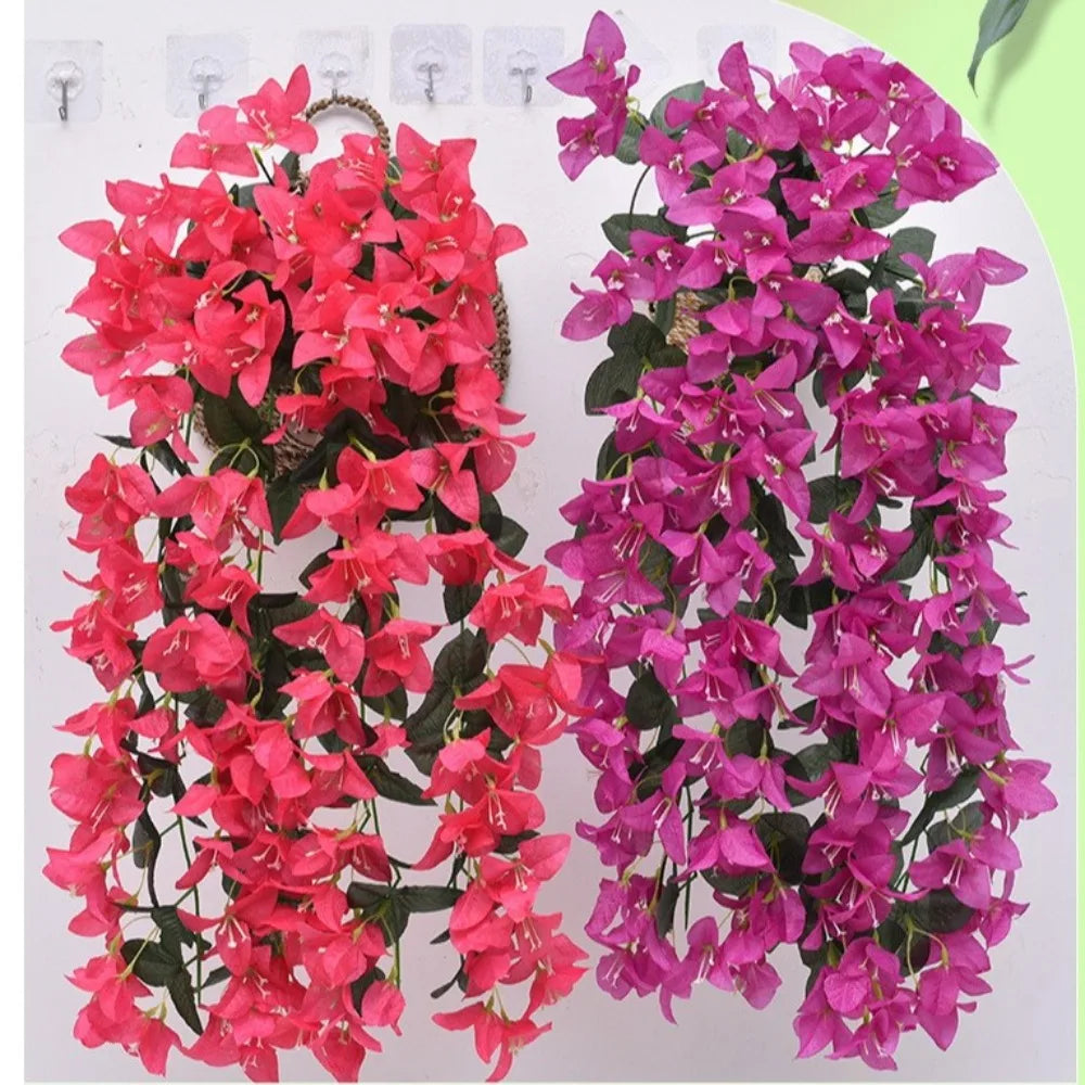 A display of vibrant pink and purple faux bougainvillea vines, showcasing colorful flowers on green foliage.