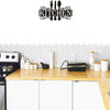 Black metal wall art sign featuring a silhouette of kitchen utensils on a white hexagonal tile background