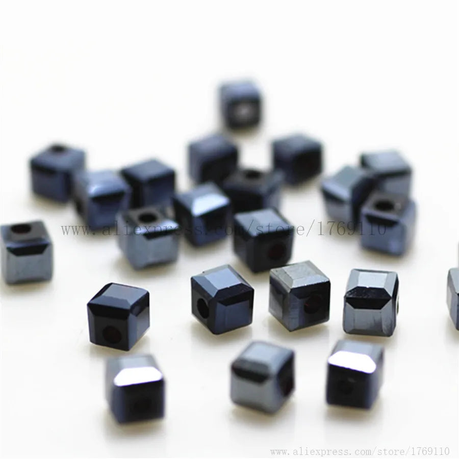 A collection of small, square-cut glass crystal beads in various shades of dark gray and black.