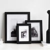 A set of three black picture frames displaying historical or architectural photographs on a white surface.