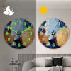A minimalist round wall clock showing a night sky and a sun, with glowing hands, displayed above a sofa.