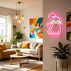 A neon light sign shaped like a black cat is mounted on a white wall in a modern living room setting.