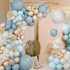 A floral arrangement of latex balloons in blue, sand, white, and gold forming a wreath display.